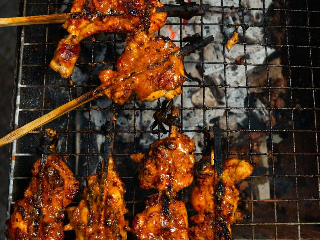 https://www.saveur.com/uploads/2021/07/22/Thai-Muslim-Style-Grilled-Chicken-Yala-grilling-Austin-Bush-1024x768.jpg?auto=webp&optimize=high&quality=70&width=1440