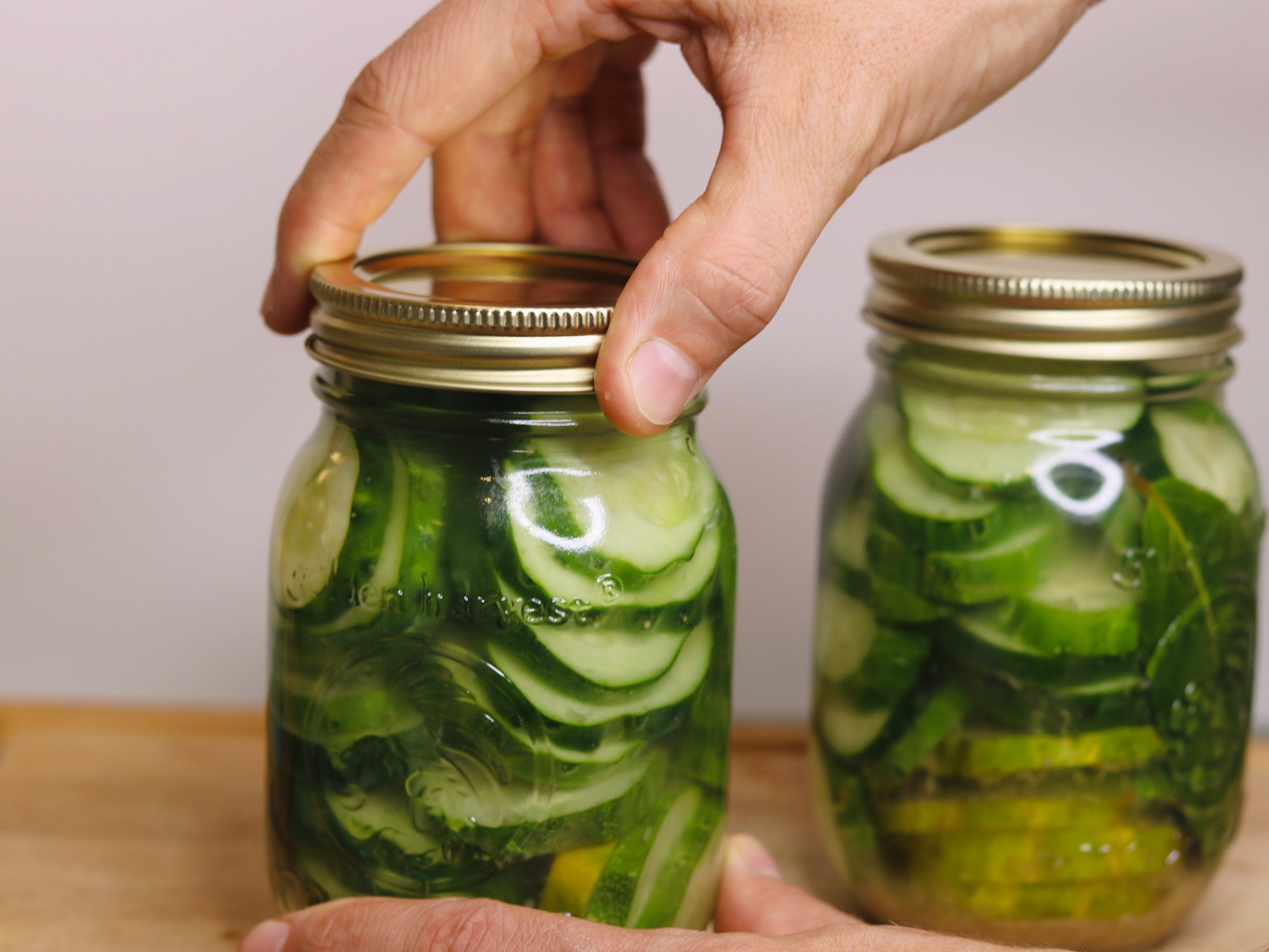 https://www.saveur.com/uploads/2021/09/16/canning-preserving-jars-of-cucumber-pickles-camilla-wynne.jpg?auto=webp